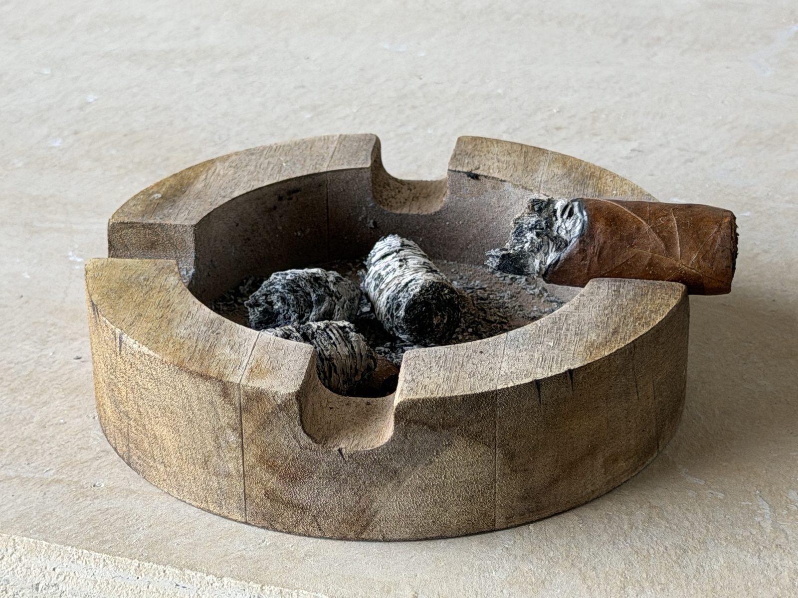 Finished Filthy Viking nub resting in a round wooden ashtray with the dropped ash beside it