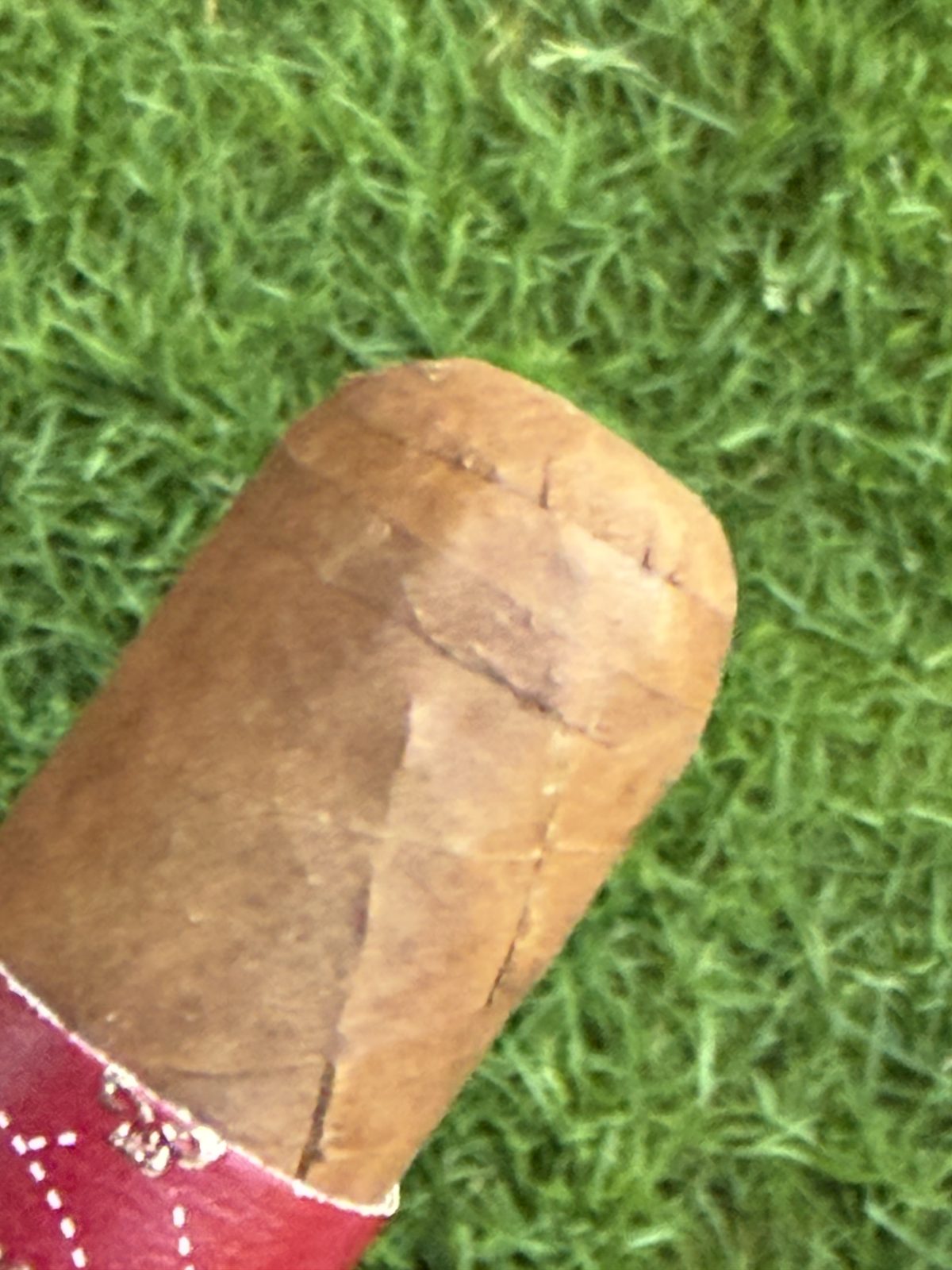 Close-up of the Asylum 13 Corojo triple cap showing cracking and a slightly unstuck seam