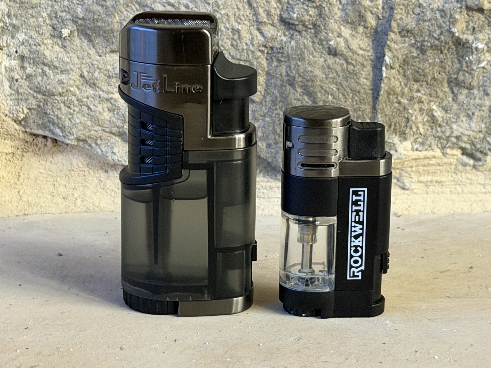 Jetline Mr. Fatboy standing next to a small Rockwell quad torch lighter for size comparison, the Fatboy several times larger