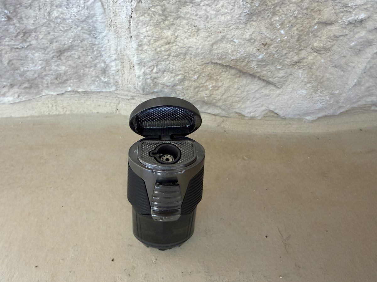 Flip cap open on the Jetline Rubanno showing the single torch jet lit and the shallow curved top lips that act as a cigar rest