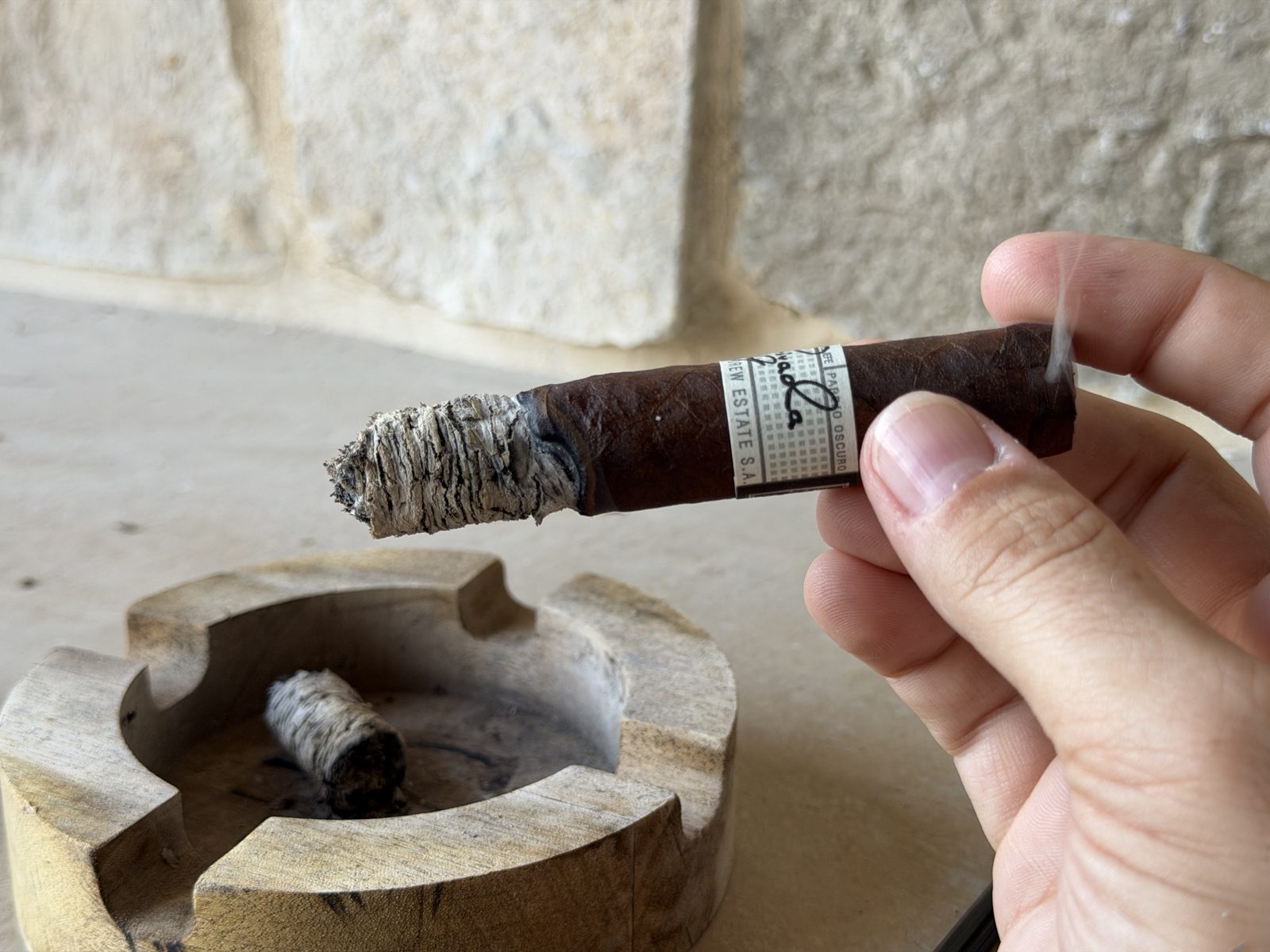 Liga Privada No. 9 Toro held over a stone ashtray with the crumbled fallen ash below