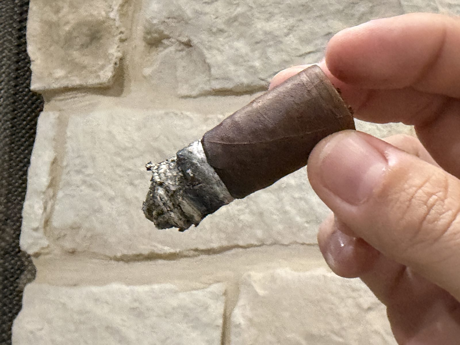 Nub of the Oliva Serie V Toro, still burning, held between two fingers