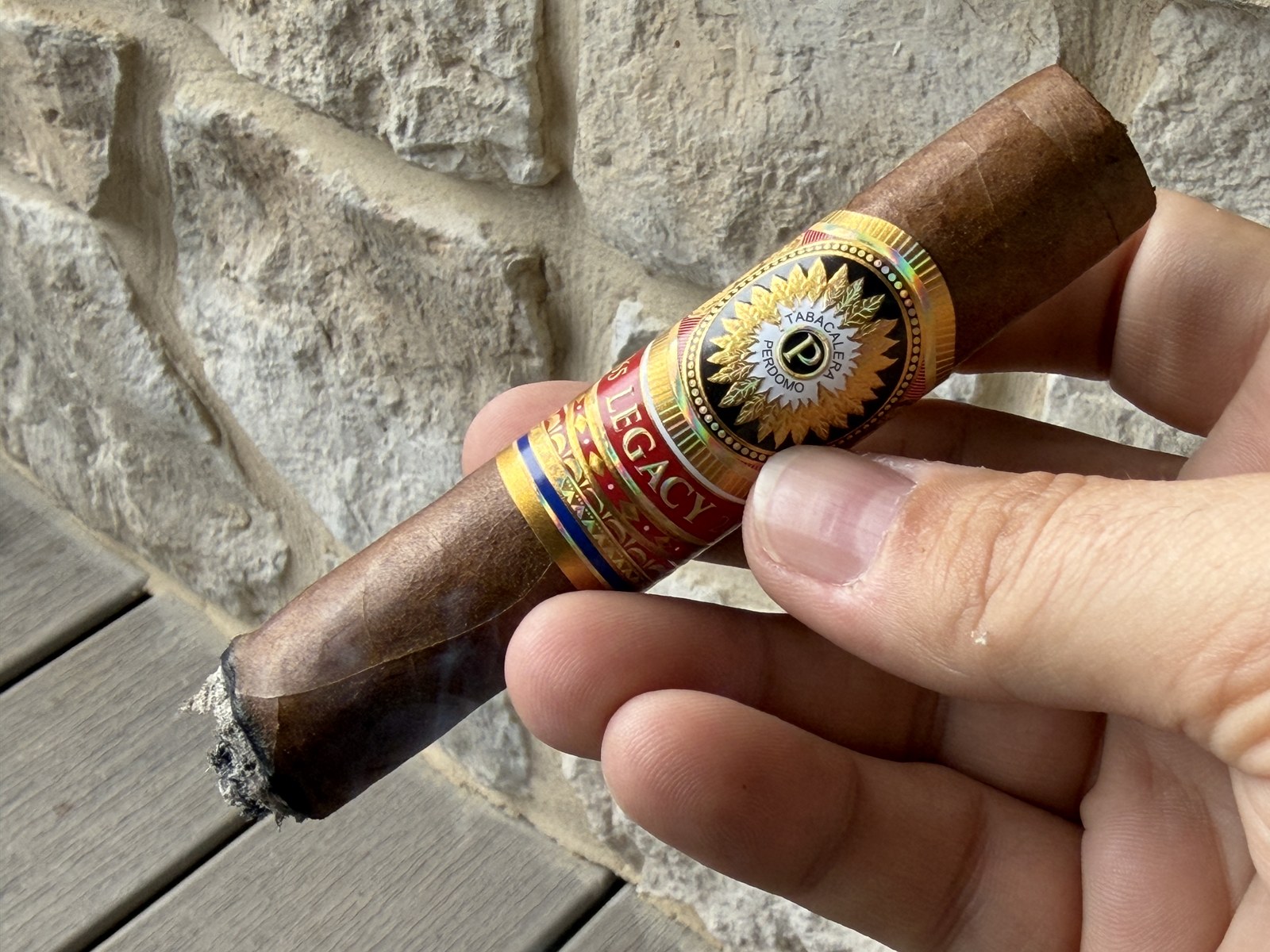 Lit Perdomo Legacy Nicaraguan Shade-Grown Epicure early in the first third, dark oily wrapper near the burn with wisps of smoke