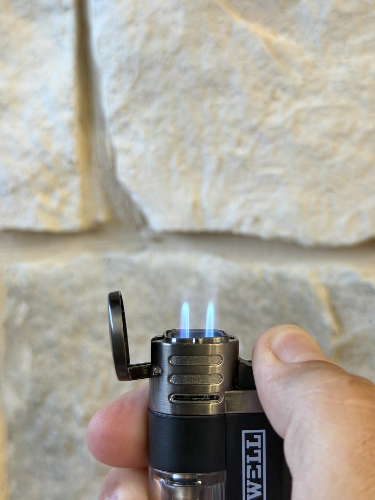 Rockwell quad torch lit in hand with four small blue flames