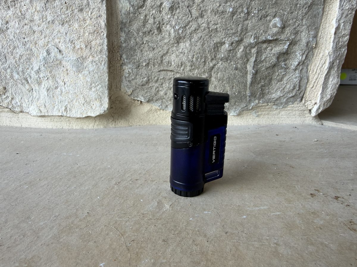 Vertigo Hawk triple jet flame lighter standing upright, black and blue body with the cap closed and VERTIGO branding on the side