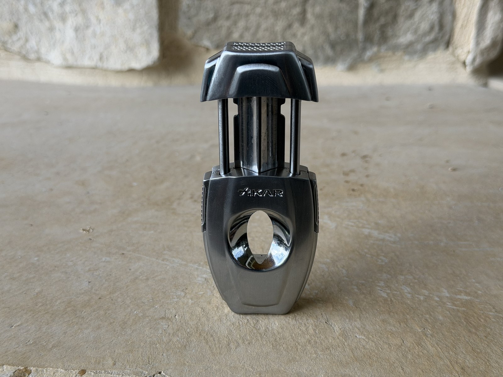 Xikar VX2 open with the spring-loaded plunger extended, slanted V-cut blade visible above the bowl