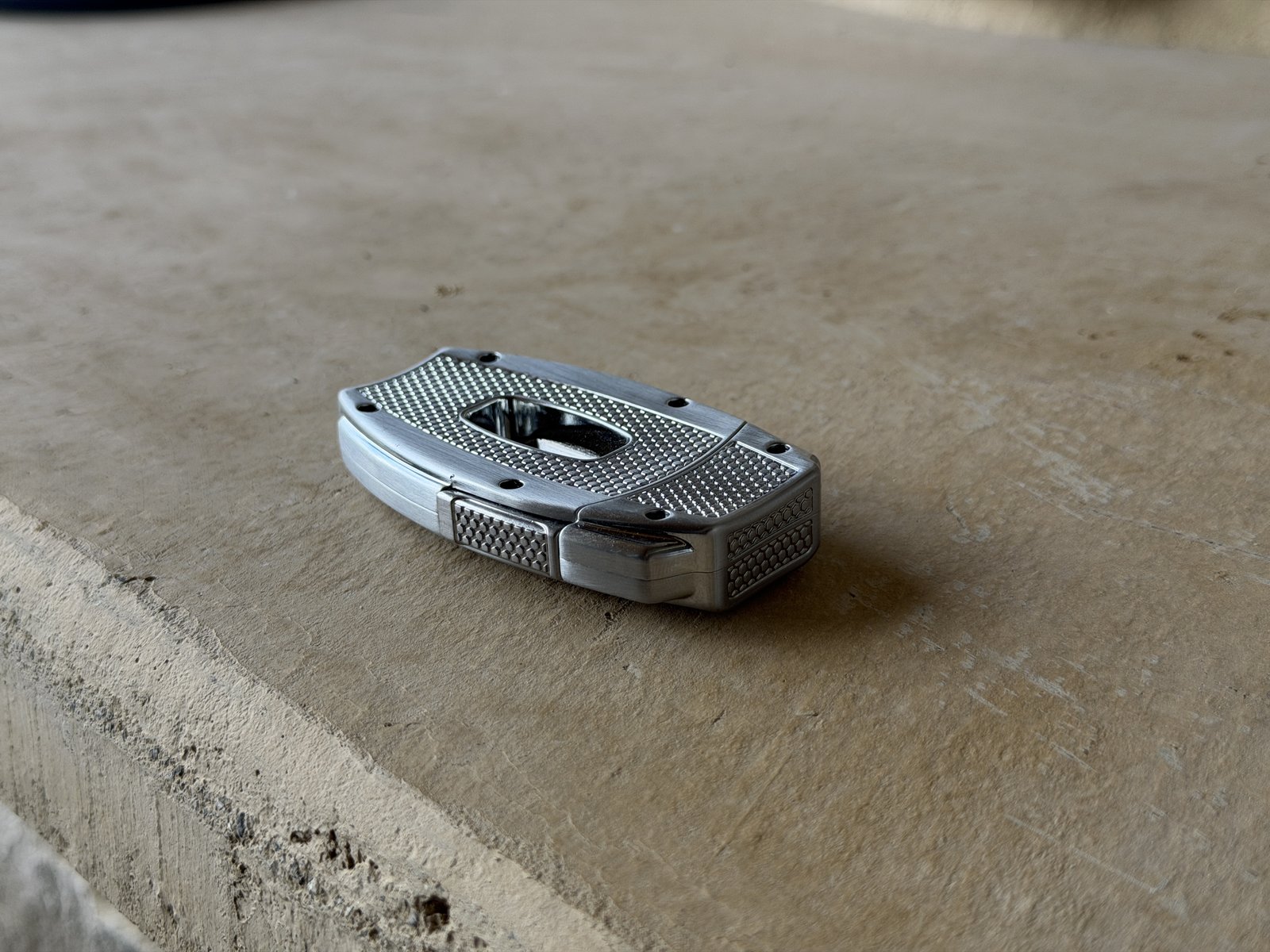 Xikar VX2 lying flat on a stone hearth showing the curved textured back side