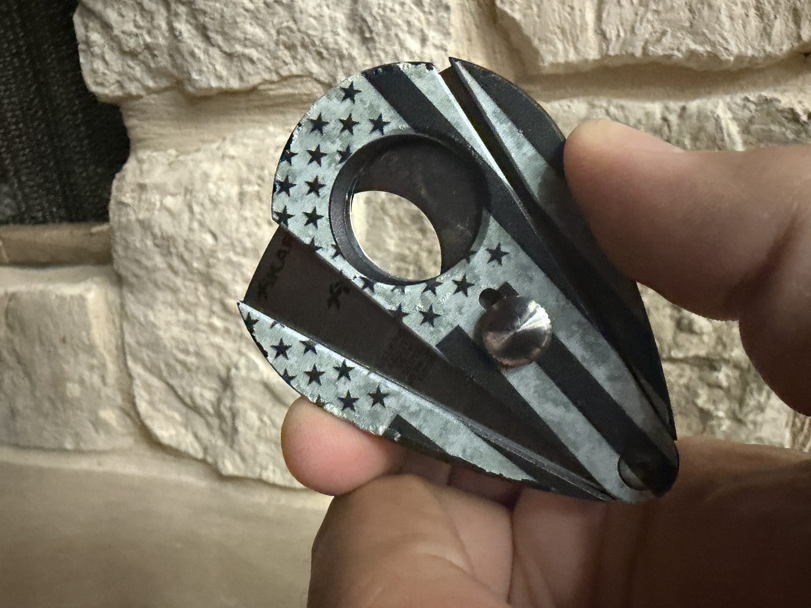 Xikar Xi2 Hero Series cutter held in hand, black and gray American flag graphic with stars and stripes