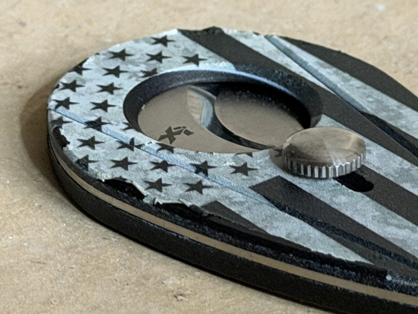 Close-up of the Xikar Xi2 Hero Series edge showing the flag graphic flaking and peeling away